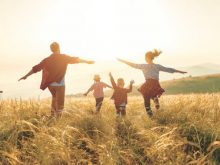 Happy family: mother, father, children son and daughter on sunset